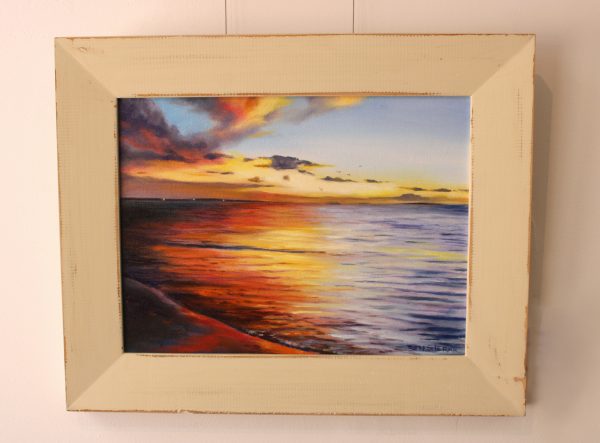 A framed original oil painting of a sunset on the Indian Ocean